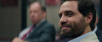 Movie still from “Gold” (2016), directed by Stephen Gaghan – A person wearing a suit and a beard; Close Up shot, Over the shoulder angle