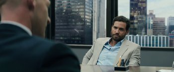Movie still from “Gold” (2016), directed by Stephen Gaghan – A man sitting at a table in front of a window; Close Up shot, Over the shoulder angle