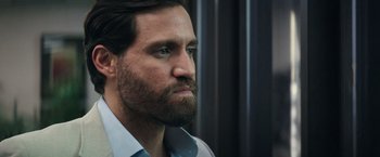 Movie still from “Gold” (2016), directed by Stephen Gaghan – A person with a beard looking to the side; Close Up shot, Over the shoulder angle