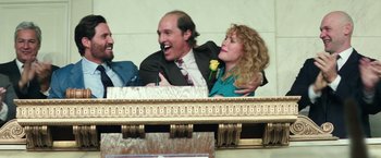 Movie still from “Gold” (2016), directed by Stephen Gaghan – A man and a woman sitting next to each other on a balcony; Medium shot, Low angle