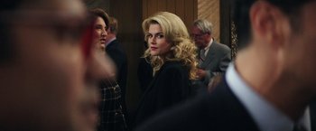 Movie still from “Gold” (2016), directed by Stephen Gaghan – A woman with blonde hair and a black jacket; Close Up shot, Over the shoulder angle