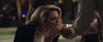 Movie still from “Gold” (2016), directed by Stephen Gaghan – A person lighting a cigarette on a woman's face; Close Up shot, Over the shoulder angle