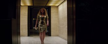 Movie still from “Gold” (2016), directed by Stephen Gaghan – A woman in a gold dress walking in an elevator; Medium shot, Low angle