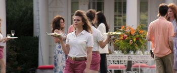 Movie still from “Gold” (2016), directed by Stephen Gaghan – A group of women holding trays of food; Medium shot, Over the shoulder angle