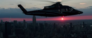 Movie still from “Gold” (2016), directed by Stephen Gaghan – A helicopter flying over a city at sunset; Extreme Wide shot, Low angle