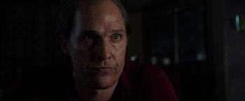 Movie still from “Gold” (2016), directed by Stephen Gaghan – A person wearing a red shirt; Close Up shot, Over the shoulder angle