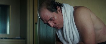 Movie still from “Gold” (2016), directed by Stephen Gaghan – An older man with a towel around his neck; Close Up shot, Low angle