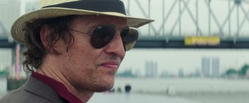 Movie still from “Gold” (2016), directed by Stephen Gaghan – A person wearing sunglasses and a hat; Close Up shot, Low angle