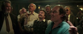 Movie still from “Gold” (2016), directed by Stephen Gaghan – A group of men standing in front of each other holding wine glasses; Medium shot, Low angle