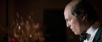 Movie still from “Gold” (2016), directed by Stephen Gaghan – A man's face with lights in the background; Close Up shot, Low angle