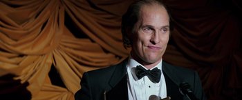 Movie still from “Gold” (2016), directed by Stephen Gaghan – A person wearing a suit and bow tie; Close Up shot, Low angle