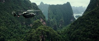 Movie still from “Gold” (2016), directed by Stephen Gaghan – A helicopter flying over a lush green forest; Extreme Wide shot, High angle