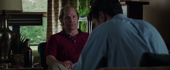 Movie still from “Gold” (2016), directed by Stephen Gaghan – Two men sitting on a couch talking to each other; Medium shot, Over the shoulder angle