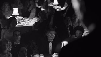 Movie still from “Good Night, and Good Luck.” (2005), directed by George Clooney – A black and white photo of a man sitting at a table; Medium shot, Over the shoulder angle