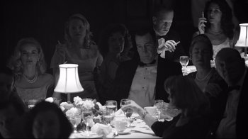 Movie still from “Good Night, and Good Luck.” (2005), directed by George Clooney – A group of people sitting at a table with wine glasses; Medium shot, Over the shoulder angle