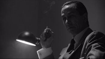 Movie still from “Good Night, and Good Luck.” (2005), directed by George Clooney – A black and white photo of a man smoking a cigarette; Close Up shot, Low angle