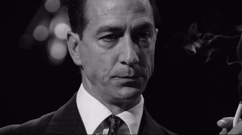 Movie still from “Good Night, and Good Luck.” (2005), directed by George Clooney – Black and white photograph of a man wearing a suit and tie; Close Up shot, Low angle