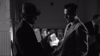 Movie still from “Good Night, and Good Luck.” (2005), directed by George Clooney – Two men in suits and hats are talking; Medium shot, Over the shoulder angle