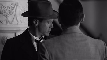 Movie still from “Good Night, and Good Luck.” (2005), directed by George Clooney – A man wearing a hat and a suit and tie; Close Up shot, Over the shoulder angle