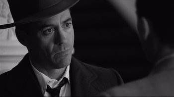 Movie still from “Good Night, and Good Luck.” (2005), directed by George Clooney – A black and white photo of a man wearing a hat; Close Up shot, Over the shoulder angle