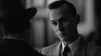 Movie still from “Good Night, and Good Luck.” (2005), directed by George Clooney – A black and white photo of a man in a suit and tie; Close Up shot, Over the shoulder angle