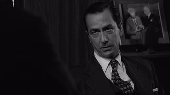 Movie still from “Good Night, and Good Luck.” (2005), directed by George Clooney – Black and white photograph of a man in a suit and tie; Close Up shot, Over the shoulder angle