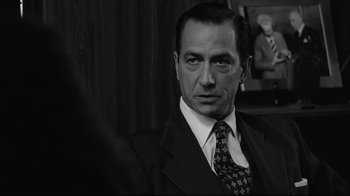 Movie still from “Good Night, and Good Luck.” (2005), directed by George Clooney – Black and white photograph of a man in a suit and tie; Close Up shot, Over the shoulder angle