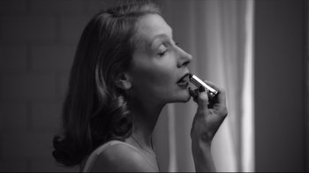 Movie still from “Good Night, and Good Luck.” (2005), directed by George Clooney – A woman is putting lipstick in her mouth; Close Up shot, Low angle
