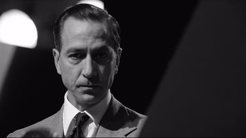Movie still from “Good Night, and Good Luck.” (2005), directed by George Clooney – Black and white photograph of a man wearing a suit and tie; Close Up shot, Low angle