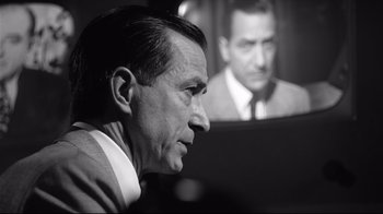 Movie still from “Good Night, and Good Luck.” (2005), directed by George Clooney – An older man in front of an older man in a suit and tie; Close Up shot, Over the shoulder angle