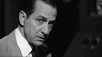 Movie still from “Good Night, and Good Luck.” (2005), directed by George Clooney – Black and white photograph of a man in a white shirt; Close Up shot, Over the shoulder angle
