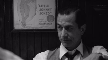 Movie still from “Good Night, and Good Luck.” (2005), directed by George Clooney – Black and white photograph of a man wearing a vest; Close Up shot, Over the shoulder angle