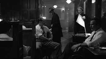 Movie still from “Good Night, and Good Luck.” (2005), directed by George Clooney – A group of men and women standing in a room; Medium shot, Over the shoulder angle