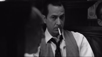 Movie still from “Good Night, and Good Luck.” (2005), directed by George Clooney – A black and white photo of a man smoking a cigarette; Close Up shot, Over the shoulder angle