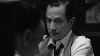 Movie still from “Good Night, and Good Luck.” (2005), directed by George Clooney – Black and white photograph of a man in a suit and tie; Close Up shot, Over the shoulder angle