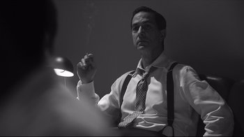 Movie still from “Good Night, and Good Luck.” (2005), directed by George Clooney – A black and white photo of a man smoking a cigarette; Medium shot, Low angle