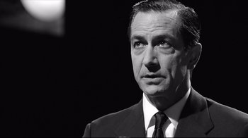Movie still from “Good Night, and Good Luck.” (2005), directed by George Clooney – Black and white photograph of a man wearing a suit and tie; Close Up shot, Over the shoulder angle