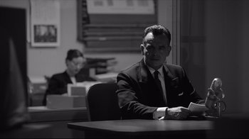 Movie still from “Good Night, and Good Luck.” (2005), directed by George Clooney – A man sitting at a table in front of another man; Medium shot, Low angle