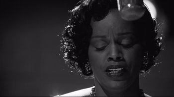 Movie still from “Good Night, and Good Luck.” (2005), directed by George Clooney – A black and white photo of a woman with her eyes closed; Close Up shot, Low angle