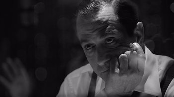 Movie still from “Good Night, and Good Luck.” (2005), directed by George Clooney – A black - and - white photo of a man holding a cell phone; Close Up shot, Low angle