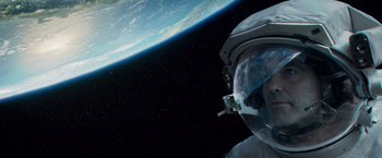 Movie still from “Gravity” (2013), directed by Alfonso Cuarón – An image of an astronaut in space with the earth in the background; Close Up shot, Overhead angle