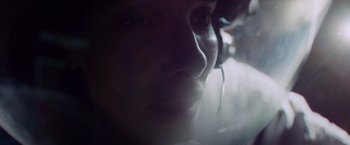 Movie still from “Gravity” (2013), directed by Alfonso Cuarón – A person with a headset in a dark room; Close Up shot, Low angle