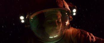 Movie still from “Gravity” (2013), directed by Alfonso Cuarón – A person wearing a helmet with lights on it; Close Up shot, Overhead angle