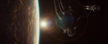 Movie still from “Gravity” (2013), directed by Alfonso Cuarón – An image of an astronaut in space with the sun in the background; Wide shot, Overhead angle