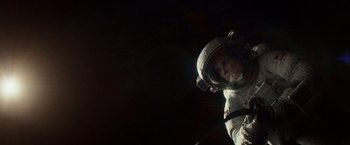 Movie still from “Gravity” (2013), directed by Alfonso Cuarón – A person in a spacesuit in a dark space; Wide shot, Overhead angle