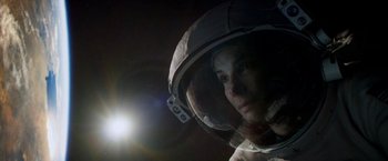 Movie still from “Gravity” (2013), directed by Alfonso Cuarón – A man in a space suit with a light in the background; Close Up shot, Low angle
