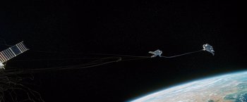 Movie still from “Gravity” (2013), directed by Alfonso Cuarón – An image of an airplane flying in the sky above the earth; Extreme Wide shot, Low angle