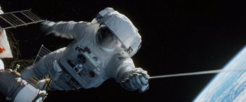 Movie still from “Gravity” (2013), directed by Alfonso Cuarón – An image of an astronaught holding a pole in space; Wide shot, Overhead angle