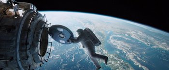 Movie still from “Gravity” (2013), directed by Alfonso Cuarón – An image of an astronaut floating in the air above the earth; Wide shot, Overhead angle