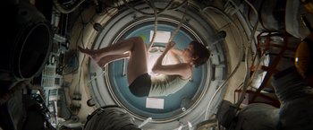 Movie still from “Gravity” (2013), directed by Alfonso Cuarón – A man hanging from a rope in a space station; Wide shot, Overhead angle